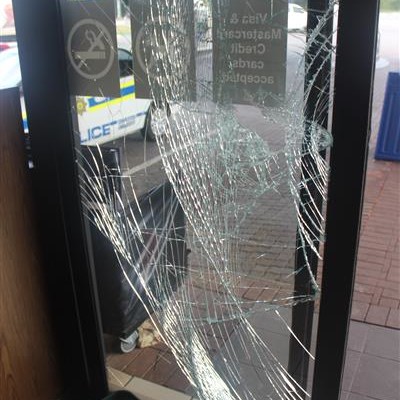 THE glass door that was smashed by the suspects to gain access to the shop.