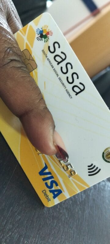 Beneficiary holding her Sassa card. Photo: Kempton Express.