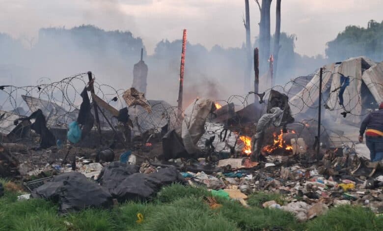 Charred debris and smoke at a fire scene after an incident involving destruction and damage.