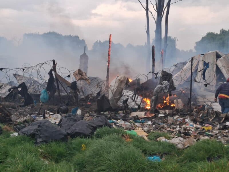 Charred debris and smoke at a fire scene after an incident involving destruction and damage.