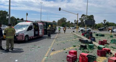 Emergency workers respond to a street accident with an ambulance and debris. Broken glass and colorful crates are scattered, conveying urgency and chaos.