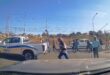 Group of people walking across street near parked EMPD police truck on a sunny day in a suburban area.