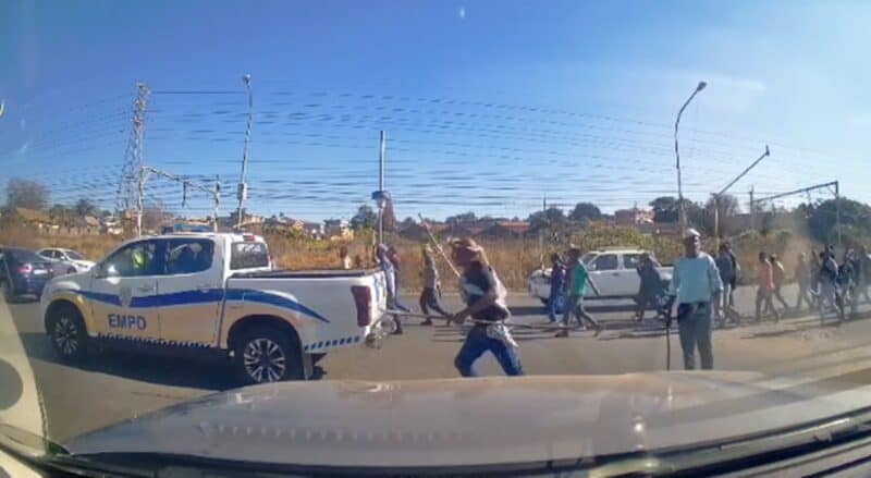 Group of people walking across street near parked EMPD police truck on a sunny day in a suburban area.