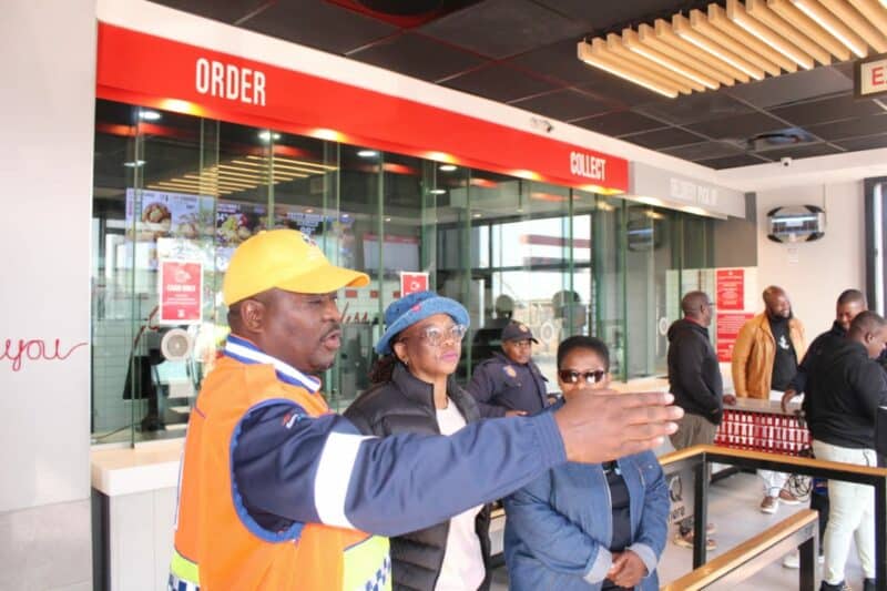 A busy restaurant scene with staff assisting customers at the order and collection counters, showcasing a vibrant dining atmosphere.