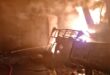 A fire scene with smoke and flames engulfing a structure, showcasing the aftermath of a significant blaze.