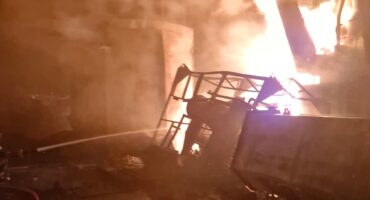 A fire scene with smoke and flames engulfing a structure, showcasing the aftermath of a significant blaze.