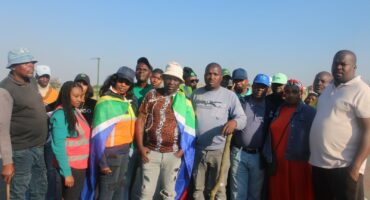 A collective of people standing side by side, proudly displaying flags that represent their identities and beliefs.
