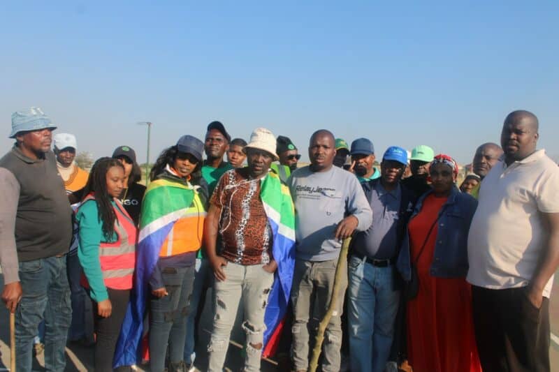 A collective of people standing side by side, proudly displaying flags that represent their identities and beliefs.