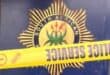 South African Police badge with a gold starburst emblem and national symbol, partially blocked by yellow “POLICE SEAL” crime scene tape.