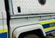 Close-up of a white-and-blue South African Police Service search and rescue truck, with a diamond-plate equipment compartment and muddy wheel arch.