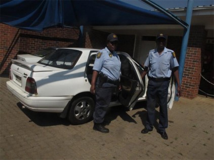 Res-Const Phuti Mantsi (left) and Const Paul Thoka, with the hijacked vehicle the Primrose SAPS recovered, last Tuesday.