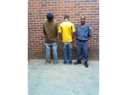 Const Grandish Makgabo, from the Primrose SAPS, keeps watch on the two men arrested for possession of dagga, on Wednesday.