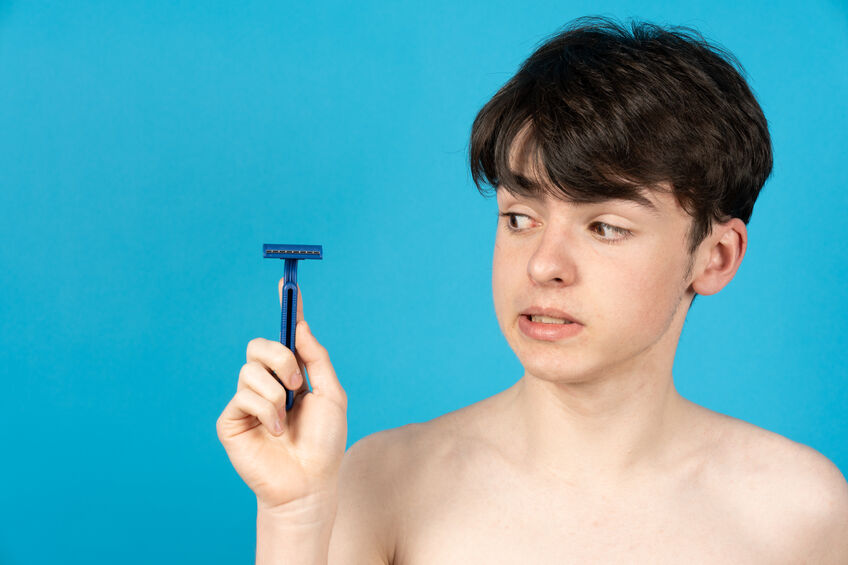 Teenager boy holding razor