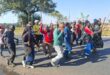 A group of demonstrators is currently moving along Pretoria Road towards Shamrock Road. The group proceeded down Rietfontein Road before turning onto Cactus Road and then right onto Pretoria Road. They are being monitored by a strong law enforcement presence, including SAPS and private security.