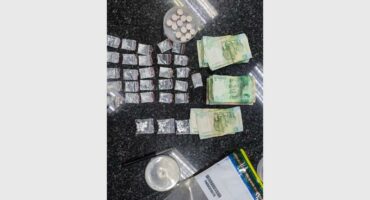 A table with a bunch of money and pills.