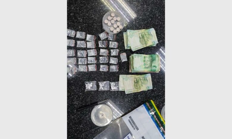 A table with a bunch of money and pills.