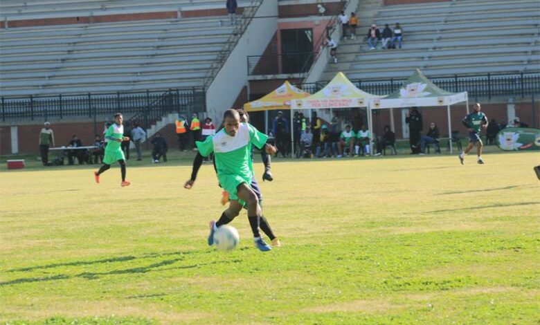 A group of young men playing soccer on a field.