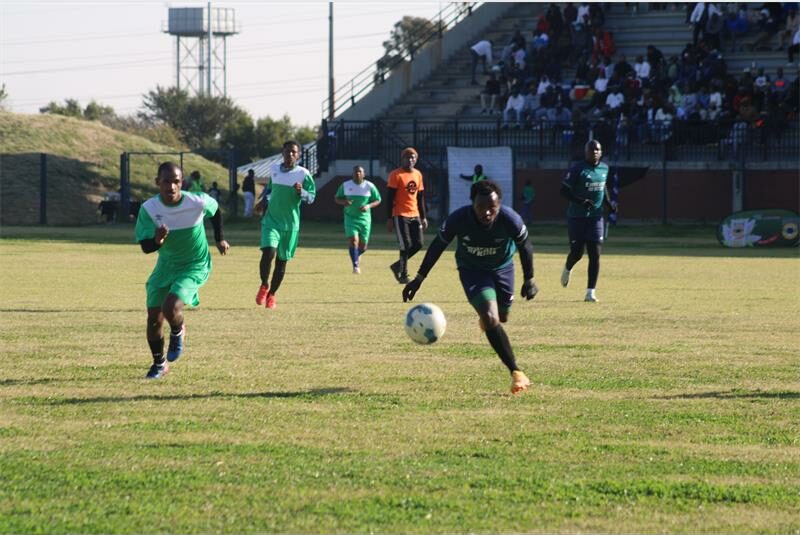 A group of soccer players are playing on the field.