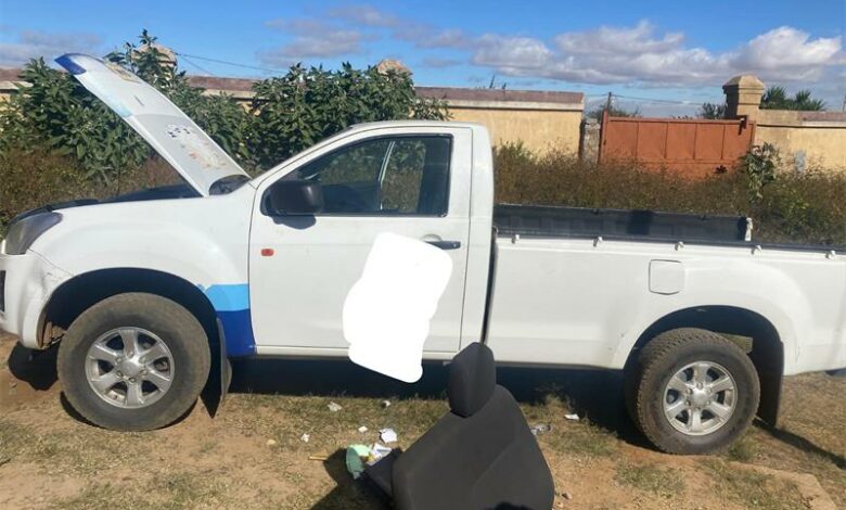 A white pick up truck with its hood open.