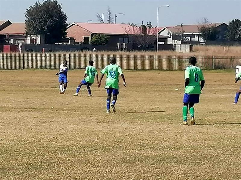 A group of men playing soccer on a field.