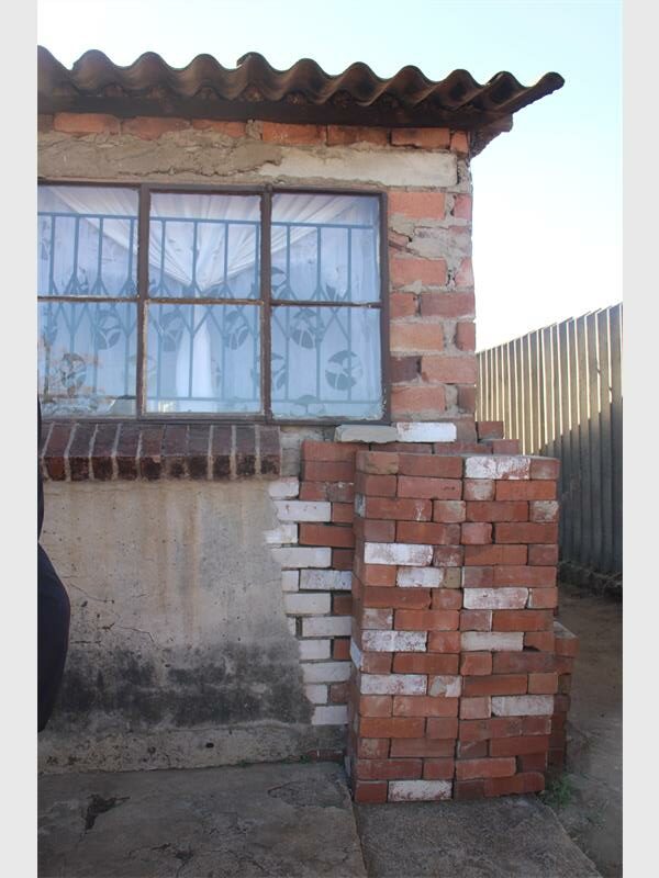 A brick wall is sitting next to a window.