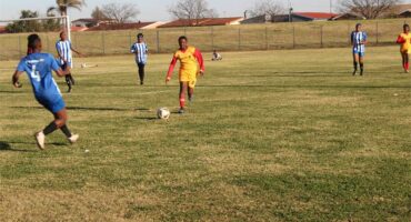 A group of young men playing soccer on a field.