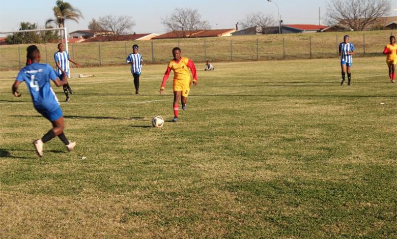 A group of young men playing soccer on a field.
