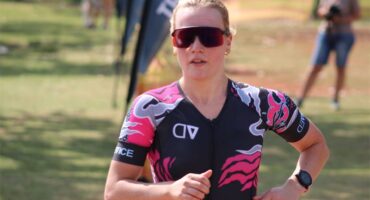 A woman in a pink and black tri suit running.