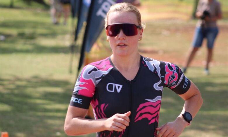 A woman in a pink and black tri suit running.