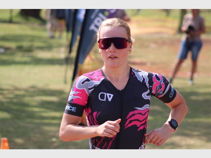 A woman in a pink and black tri suit running.