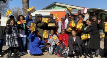 A group of people holding boxes of food.