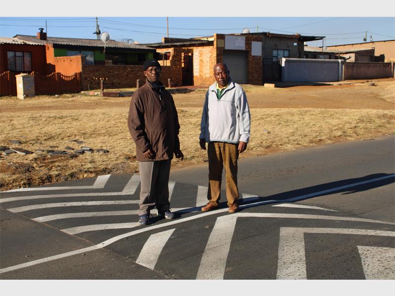 After years of speeding cars and crashes on Thema Road, Kwa-Thema residents finally find relief and safer nights thanks to new speed humps, but they’re still frustrated over the CoE’s slow response.