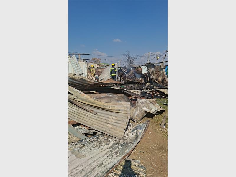 Firefighters battled flames at Marikana informal settlement while law enforcement monitored a tense situation following the alleged forced removal of occupants.