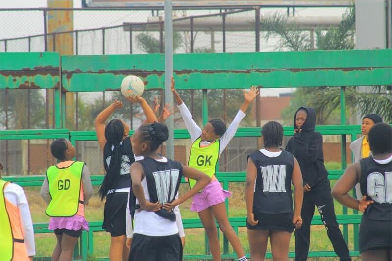 Girls' football training session on an outdoor field in Africa.