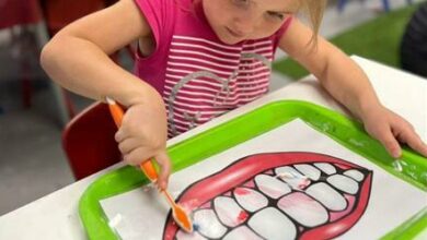 Kiyana Devraj focuses on brushing the paper teeth.