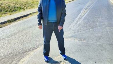 Khalil Patel gestures toward a pothole on Bramley North's Boero Road.