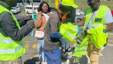 Mitchwear team gives the street marshal a hamper on Rivonia Road.