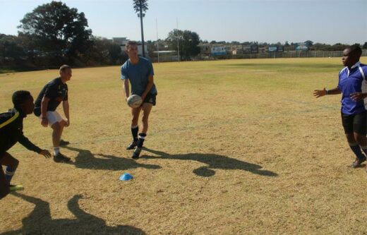 Alec Fulton passes to an open Tafadzwa Mdege, while Connor Byrne and Ontathile Mmachacha chase during the Grade 11 boys' rugby practice on Spring Day.
