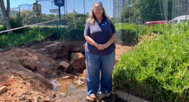 Ward 103 councillor stands next to an excavation with exposed Johannesburg Water leaking pipe at Benmore Shopping Centre. Photo: Xoliswa Zakwe