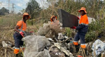 Ricardo Moyo, Duduzile Nsibande, and Evidence Vundla cleaning up Sandspruit River on Sandown on June 9, 2026. Photo: Xoliswa Zakwe