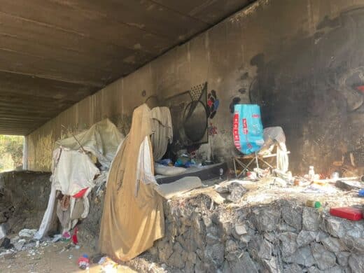 Bedding and personal belongings are the Katherine Street Bridge, where occupants have created temporary shelters along the Sandspruit River. Photo: Xoliswa Zakwe