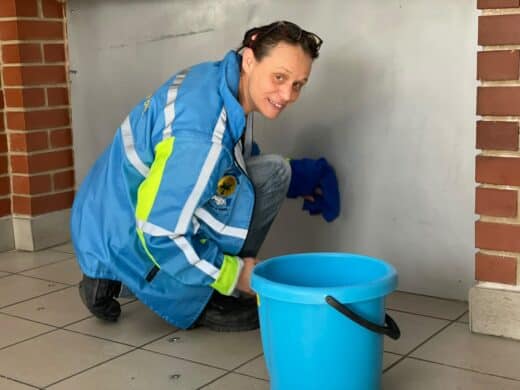 Sandton CPF member Stacey Jones scrubs a wall at Sandton Police Station during the Mandela Day cleanup on July 18, 2026.
