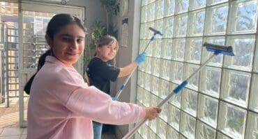 Ruhani Kapoor and Emily Johnes-Wadge help wash the windows at Sandton Police Station on July 18, 2026.