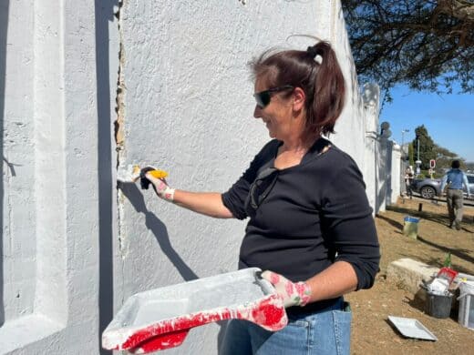 Caroline Human paints the wall during the Mandela Day restoration initiative on July 18, 2026