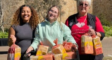 Volunteers Mia Rogers, Gabriela McKinnon and 67 Blankets ambassador Jo Corlett help spread warmth and kindness by handing out bread, biscuits and handmade knitted items to passers-by as part of the annual Mandela Day initiative. Photo: Xoliswa Zakwe