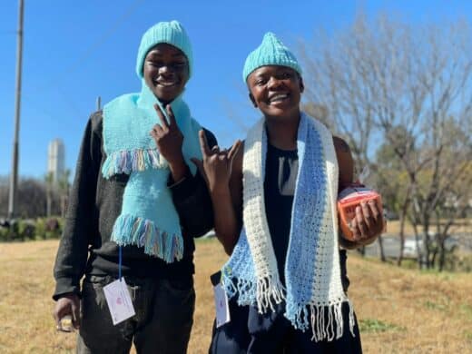 Thato Thipe and Morny Tsebe proudly show off their handmade scarves and beanies received during the 67 Blankets Secret Scarf Mission at Rosebank Union Church. Photo: Xoliswa Zakwe