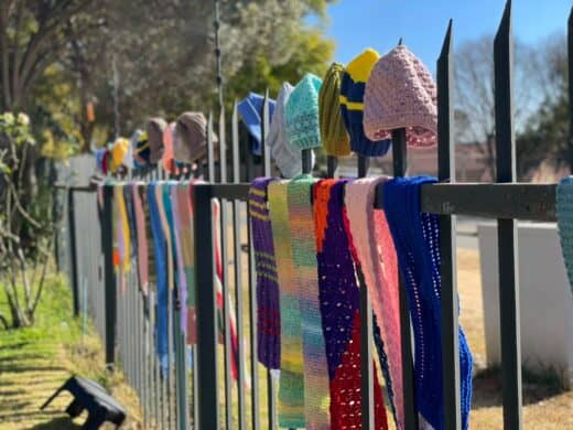 Handmade scarves and beanies hang along the fence of Rosebank Union Church, waiting for anyone in need to take one during the annual 67 Blankets Secret Scarf Mission. Photo: Xoliswa Zakwe