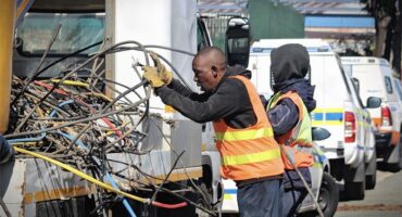 A City Power worker carefully handles a tangled mass of cables during the operation on August 13, 2026. Photo: Itumeleng Maloka