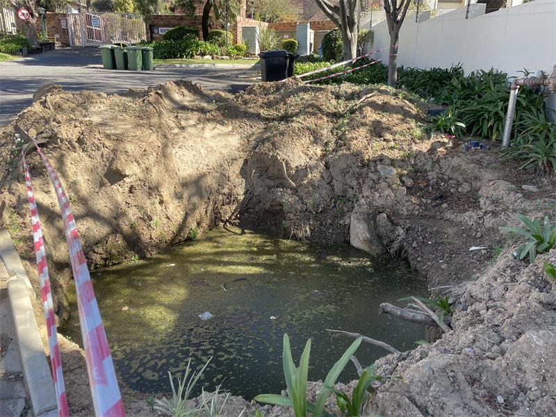 The water-filled excavation outside La Piazza Complex before Johannesburg Water completes the repair work on July 24, 2026.