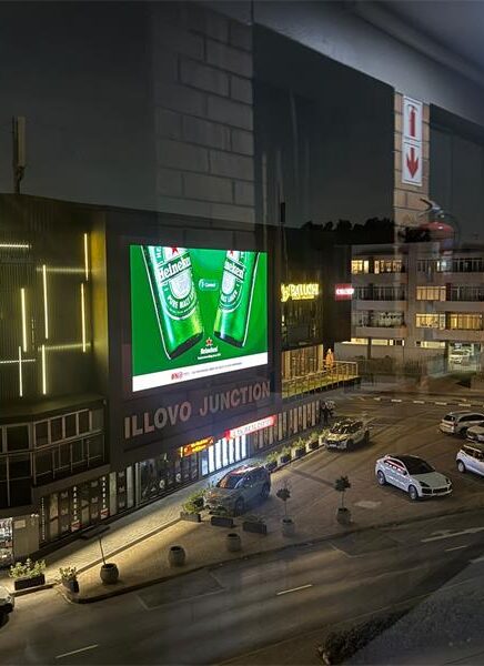 A giant digital billboard illuminates Illovo Junction at night, advertising the busy Oxford Road and Corlett Drive intersection. Photo: Supplied